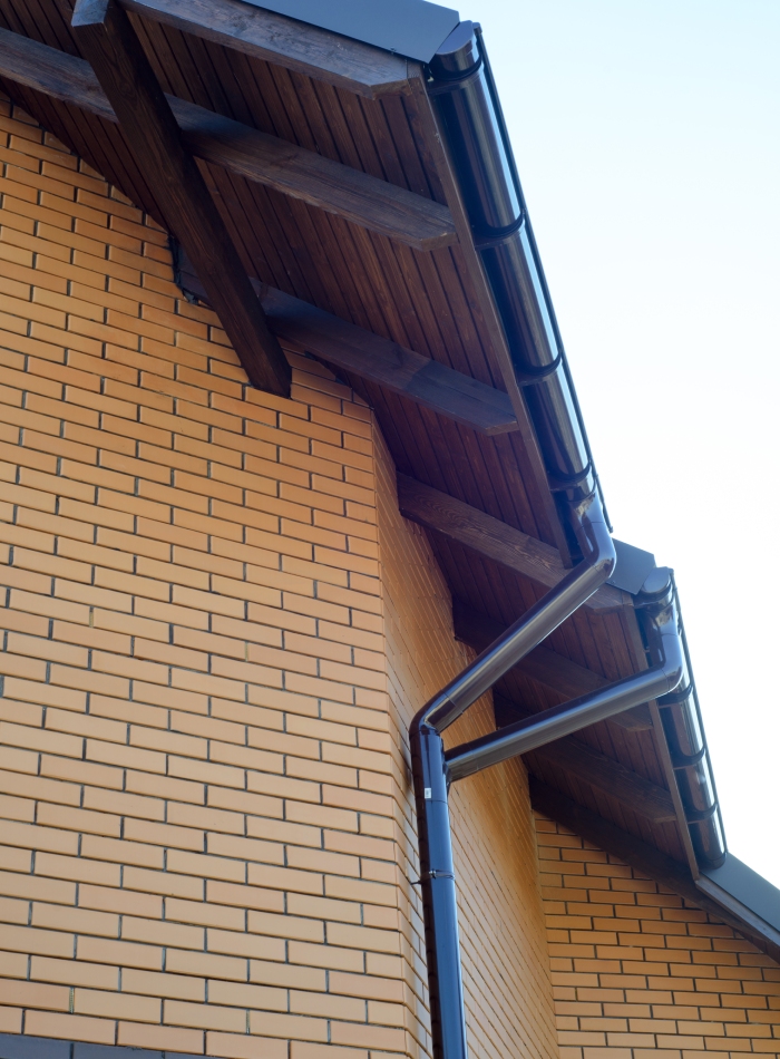 Maison en brique avec gouttières et sous-toiture en bois