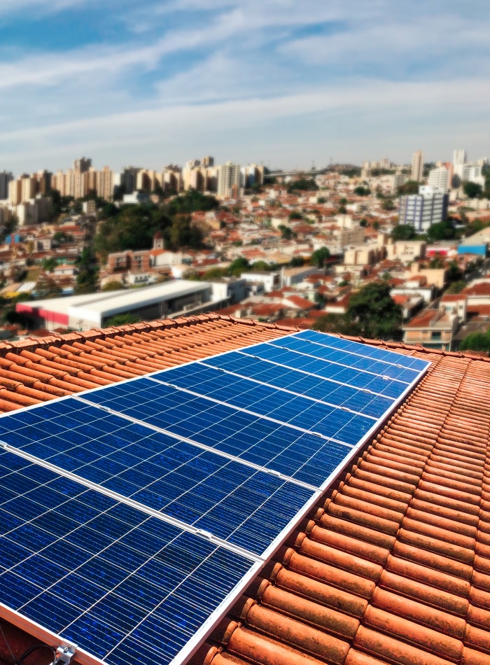 Panneaux solaires installés sur une toiture en tuiles rouges en milieu urbain