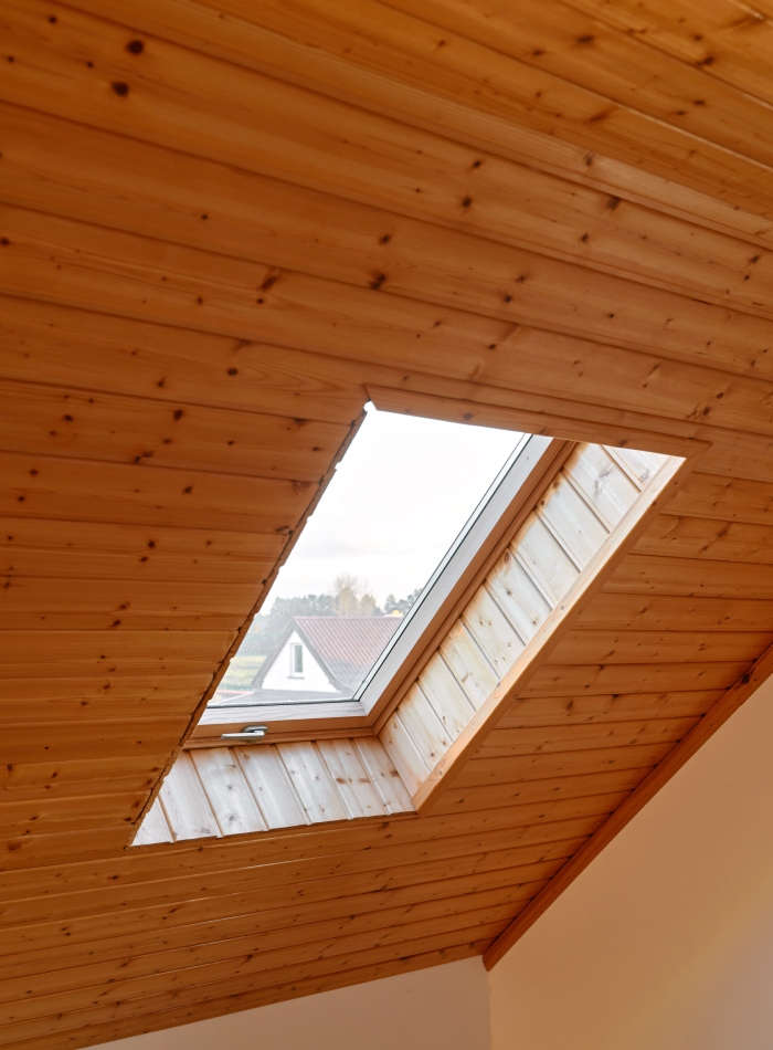 Fenêtre de toit intégrée dans des combles avec habillage en lambris bois