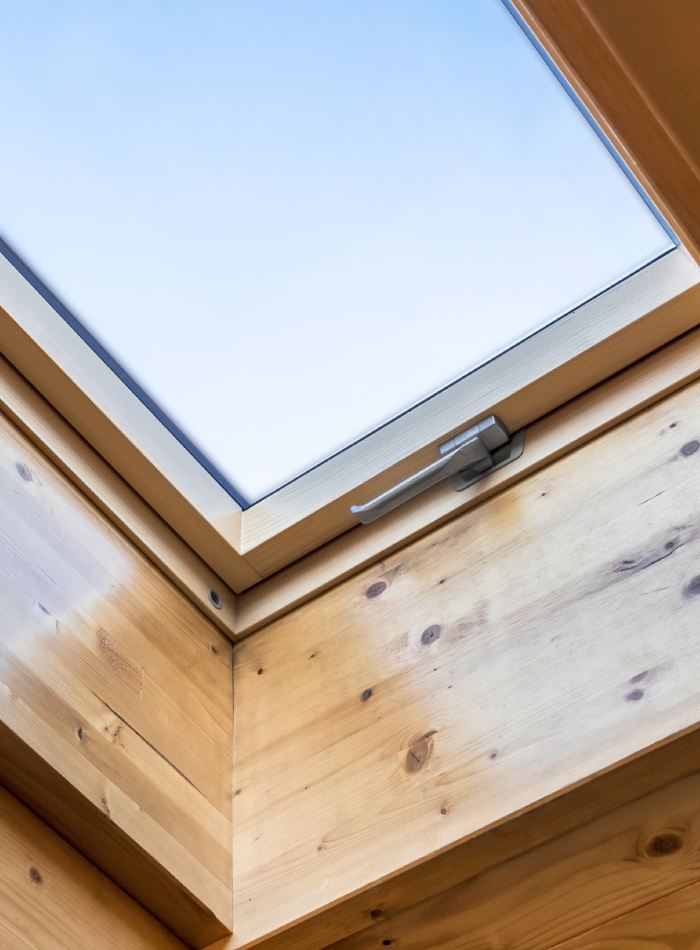 Fenêtre de toit en bois avec finition intérieure soignée et poignée d’ouverture